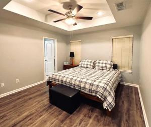 a bedroom with a bed and a ceiling fan at Mendoza Villa - Longview Tx in Longview