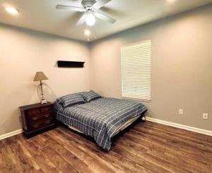a bedroom with a bed and a ceiling fan at Mendoza Villa - Longview Tx in Longview