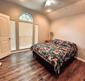 a bedroom with a bed with a floral comforter at Mendoza Villa - Longview Tx in Longview +1 photo