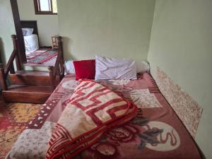 a bedroom with a bed with a blanket on it at Auberge Toubkal Amsouzart Aitst Idar in Tizgui