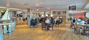 a restaurant with wooden floors and tables and chairs at Beach Haven at Berwick in Berwick-Upon-Tweed