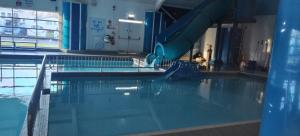 a swimming pool with a water slide in a building at Beach Haven at Berwick in Berwick-Upon-Tweed