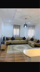 a living room with two couches and a table at Appartement 2 chambre in Gabès