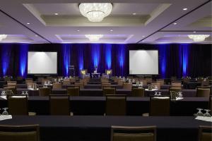 ein Konferenzraum mit Tischen, Stühlen und Bildschirmen in der Unterkunft Milwaukee Marriott West in Waukesha