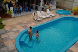 a man and a woman standing in a swimming pool at Carey Lodging in Tortuguero