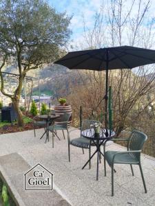 a group of tables and chairs with an umbrella at Ca' Gioel in Sedrina