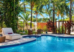 a swimming pool with chairs and palm trees at Solanza Hotel Hacienda in Cancún