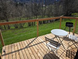 a wooden deck with a table and chairs on it at Le Nid Douillet du Tacot in Le Thillot +5 photos