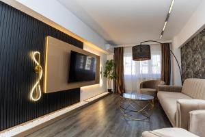 a living room with a couch and a tv on a wall at Old Town Luxury 1 in Târgovişte