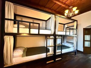 a room with three bunk beds in a house at Tropicana La Catedral in Antigua Guatemala
