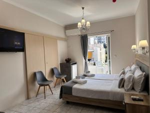 a bedroom with a bed and two chairs and a window at Airport Suites Michelle in Spata +90 photos