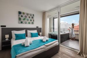 a woman standing on a balcony in a bedroom with a bed at Villa Muller Apartments in Split