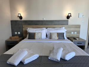 a bedroom with a large bed with two pillows at Airport Suites Michelle in Spata