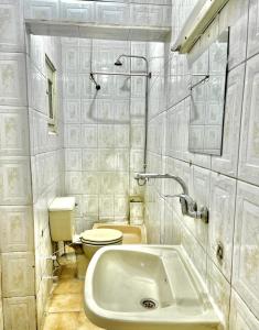 a white bathroom with a toilet and a sink at Kelany Palace Hotel Aswan in Aswan +49 photos