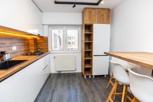 a kitchen with white cabinets and a wooden counter top at Old Town Luxury 1 in Târgovişte