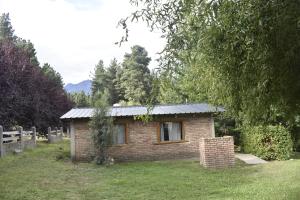 a small brick house with a metal roof at Camping El Paraíso in El Hoyo