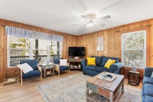 a living room with blue couches and a tv at Happy Ours in Corolla