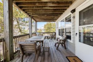 a wooden deck with tables and chairs on a house at Happy Ours in Corolla