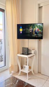 a tv on a wall with a white table at Apartamento Turístico Casa Bari in Olivenza