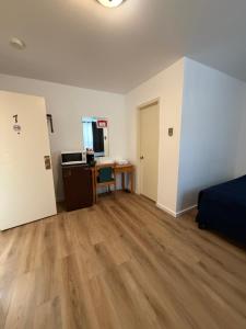 an empty room with a bed and a desk at Lake-Vu Motel in Kenora