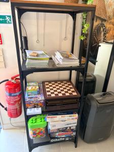 a book shelf with books and games on it at Le Ptit studio du vieux moulin in Rochefort