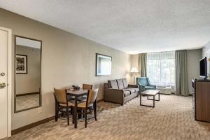 a living room with a couch and a table at Riverview Inn & Suites, an Ascend Collection Hotel in Rockford