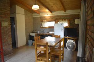 a kitchen with a table and chairs and a refrigerator at Camping El Paraíso in El Hoyo