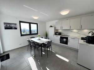 a kitchen and dining room with a table and chairs at BILEANCA - Neubau-Ferienwohnungen Rheinhausen Europa-Park in Rheinhausen