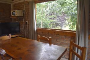 a dining room with a table and a large window at Camping El Paraíso in El Hoyo