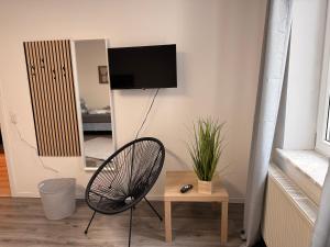 a room with a chair and a television on a wall at Casa Daniela Residence in Vilshofen an der Donau