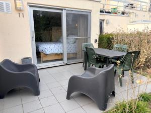 a patio with a table and chairs and a bed at Le Ptit studio du vieux moulin in Rochefort