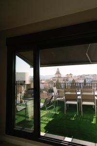 a window view of a balcony with chairs and tables at Casa Deitania I in Caravaca de la Cruz