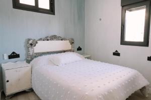 a white bed in a bedroom with a window at Casa Deitania I in Caravaca de la Cruz