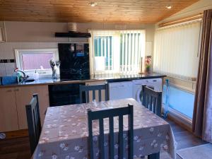 a kitchen with a table and a table and chairs at Afon Lodge in Maesmynis