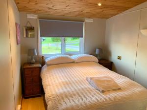 a bedroom with a large bed with a window at Afon Lodge in Maesmynis