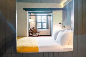 a bedroom with a large bed and a table at Het Sluiswachtershuisje in Maassluis