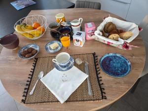 a wooden table with breakfast food on it at Chez Titelle in Saint-Laurent-de-la-Salanque +15 photos