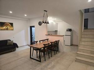 a dining room and kitchen with a table and chairs at Gurgen Cottage in Ureki