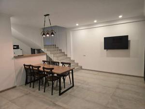 a dining room with a table and chairs and a tv at Gurgen Cottage in Ureki