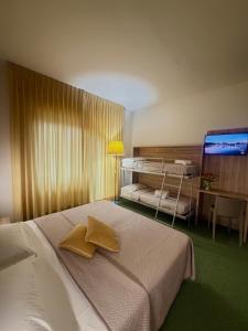 a bedroom with two beds and a flat screen tv at Hotel Palombella & Restaurant in Frosinone +56 photos