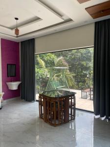 a room with a large glass door with a table at Neev holiday homes in Vythiri