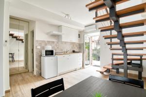 a kitchen with white cabinets and a spiral staircase at SM Beach Residence in Petrovac na Moru