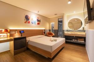 a hotel room with a bed and a mirror at Spa Motel - Radial Leste in São Paulo