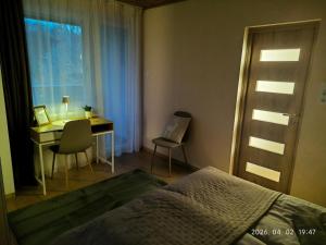 a bedroom with a desk and a bed and a table and chairs at Döbrönte MagLak in Döbrönte