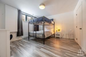 a bedroom with a canopy bed and a wooden floor at Aphrodite- Piscine sauna et spa in Pont-Rouge