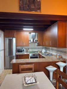 a kitchen with wooden cabinets and a table with a counter top at Area 3B in Camariñas