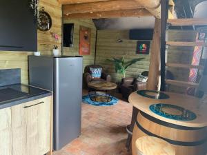 a kitchen with a refrigerator and a table at Le Garage in Lamotte-Beuvron