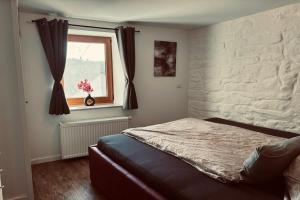a bedroom with a bed and a window at Ferienparadies in der Vulkaneifel in Roth