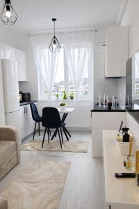 a kitchen and living room with a table and chairs at White Pearl Residence in Roşu
