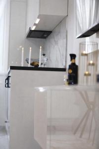 a white kitchen with candles on a counter at White Pearl Residence in Roşu